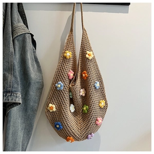 Detailed close-up of handmade crochet tote bag with colorful 3D floral decorations