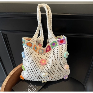 Dettaglio della borsa tote all'uncinetto bianca con fiori 3D colorati e trama a rete