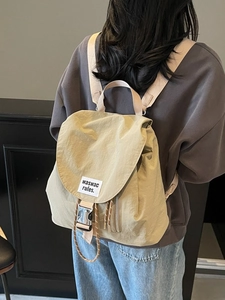 Minimalist beige canvas backpack with flap buckle and large capacity on model