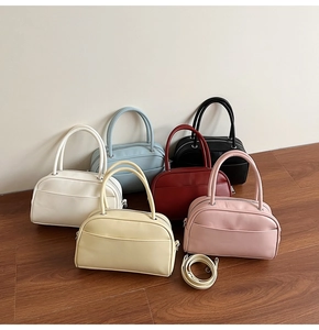 Showcase of minimalist pillow bags in six colors with leather texture and top handles