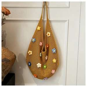Detailed close-up of handmade yellow crochet tote bag with colorful 3D floral accents