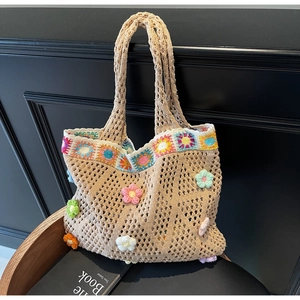 Dettaglio della borsa tote all'uncinetto con fiori 3D colorati e trama a rete
