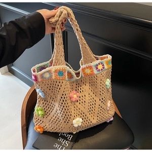 Dettaglio della borsa tote in crochet kaki con fiori colorati e trama a rete boho