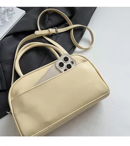 Detail of lychee pattern handbag featuring a front phone pocket and adjustable strap