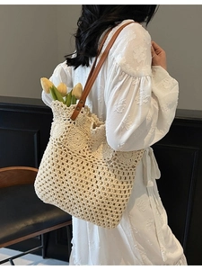 Grande borsa tote beige all'uncinetto con manici marroni indossata dalla modella