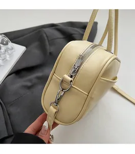 Close-up of premium silver-tone hardware and stitching on beige leather pillow bag