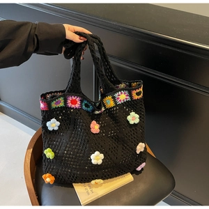Dettaglio borsa tote nera in maglia con fiori 3D all'uncinetto e quadrate granny