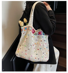 Detail of bohemian crochet tote bag with colorful floral embroidery and bead accents