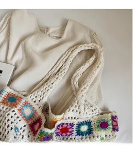 Detail of colorful crochet sunflower pattern on a cream knit tote bag with thick handles