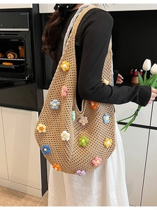 Handmade woven tote bag with colorful 3D floral accents and a large shoulder strap