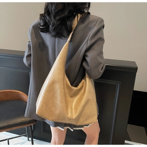 Close-up of khaki PU leather tote bag with vintage texture and pleated crescent design