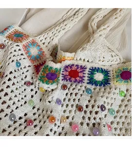 Close-up of bohemian crochet knit bag featuring colorful granny squares and beads