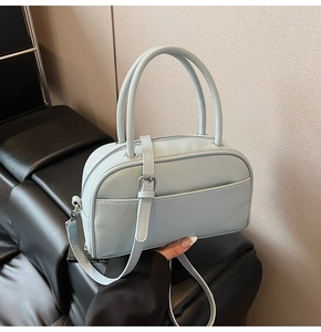 Detail of light blue faux leather Boston bag with silver hardware and adjustable strap