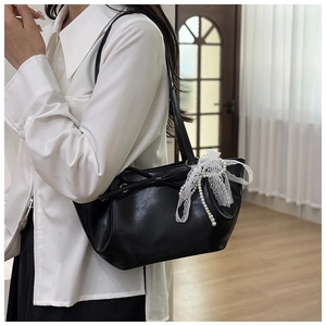 Détail du sac seau plissé noir avec nœud et pendentif en dentelle et perles chic