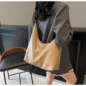 Detailed view of khaki large capacity hobo bag on shoulder for daily commute outfits