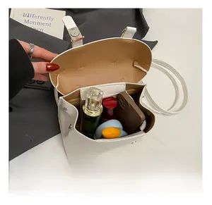 Detail view of white crossbody bag interior showing storage for cosmetics and essentials