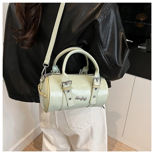 Detailed side view of mint green patent leather cylinder bag with silver buckles