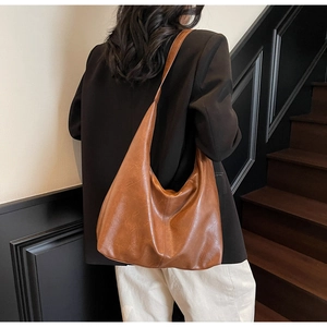 Brown vintage PU leather hobo bag side view on shoulder showing large capacity and texture