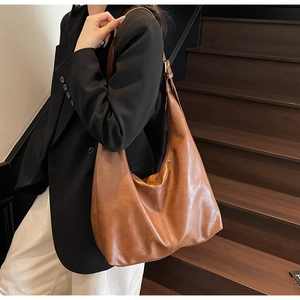Macro detail of vintage brown PU leather texture and adjustable strap on tote bag
