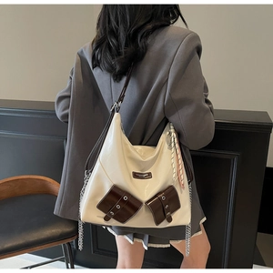 Détail du sac cabas crème avec poches marron, chaîne argentée et bandoulière de mode