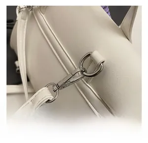 Detail shot of the shiny silver metal spring hook and white lychee grain leather bag