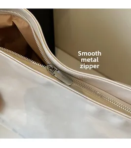 Detail of smooth gunmetal zipper and high-quality cream leather on a large tote bag