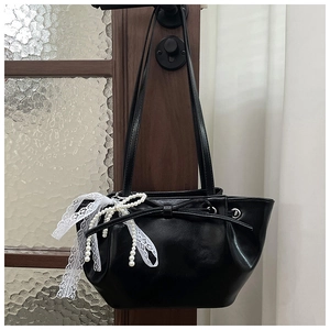 Détail du sac bandoulière en cuir PU noir avec dentelle blanche, perles et nœud papillon