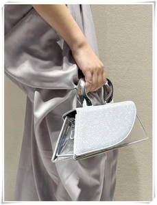 Macro view of silver trapezoid handbag with sparkling rhinestones and metallic finish