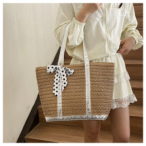 Close-up of straw tote bag with silver sequins and a black and white polka dot scarf