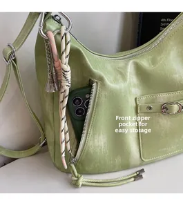 Detail view of front zipper pocket on green tote bag showing smartphone storage capacity