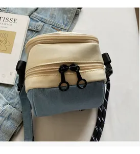 Detail of smooth two-way metal zippers on a stylish contrast color mini crossbody bag