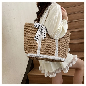 Detail of straw tote bag with silver sequins and black white polka dot ribbon