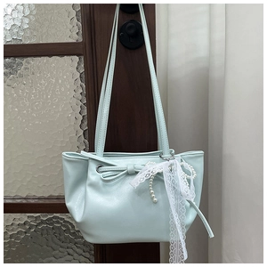 Détail du sac seau en PU bleu clair avec nœud décoratif et charms en dentelle et perles