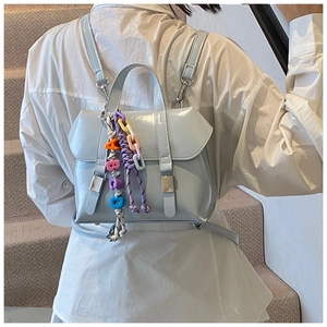 Close-up of light blue mini backpack with glossy finish and colorful alphabet bead charms