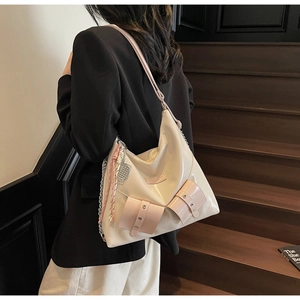 Détail d'un grand sac fourre-tout crème et rose avec chaîne argentée et décor tressé