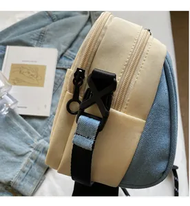 Detail of canvas and denim patchwork bag with dual ring zippers and durable buckle