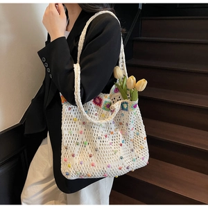 Macro detail of hand-woven tote bag with colorful bead accents and floral patterns