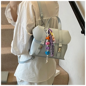 Detailed back view of a light blue PU backpack with colorful letter charms and buckles