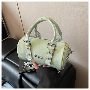Detail of mint green Boston bag showing glossy patent leather and silver logo plate