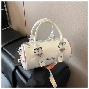 Detail of white patent leather boston bag with pink contrast trim and silver hardware