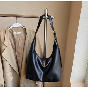 Detailed close-up of a large black Hobo bag with natural leather texture and gold hardware