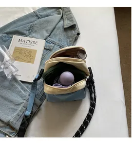 Interior view of denim crossbody shell bag showing spacious compartments and zip closures
