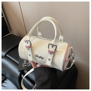 Detail of white patent leather Boston bag with pink trim and silver metal logo buckle