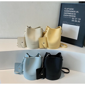 Group shot of colorful vintage bucket bags in cream, yellow, blue, and black faux leather