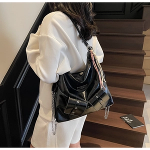 Détail du cabas noir en cuir verni froissé avec chaîne en métal et poches utilitaires