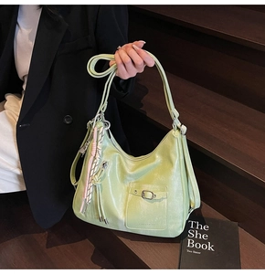 Detail of light green hobo tote showing soft leather texture and stylish buckle pocket