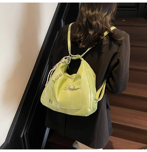 Detail of avocado green leather tote bag with silver hardware on a model back