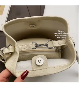 Detail of cream bucket bag showing magnetic closure and interior zipper pocket