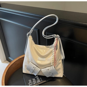 Détail d'un sac cabas en cuir brillant blanc avec poches et pompon tissé élégant