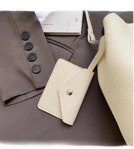 Macro shot of lychee grain leather handbag with small envelope pouch and silver snap button